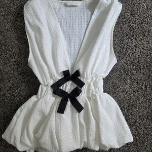 Elegant White Sleeveless Top with Black Bow Accents